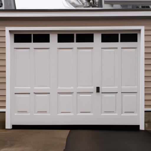 Modern paneled garage door on a colonial Dover, MA home, closed on a cloudy day.