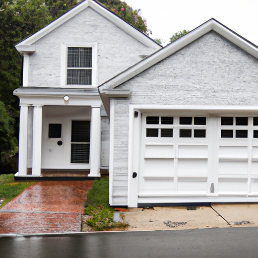 Suburban Dover home with a white two-car garage door closing under an overcast New England sky.